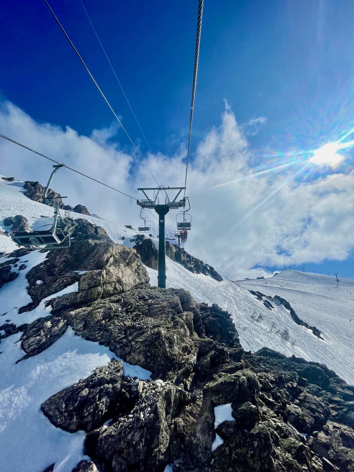 Chairlift over rocky snowy terrain at Cerro Catedral